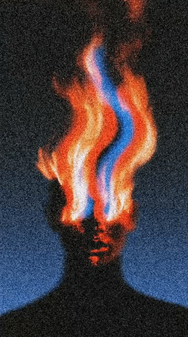 Grainy silhouette of a person whose head is consumed by orange and blue flame